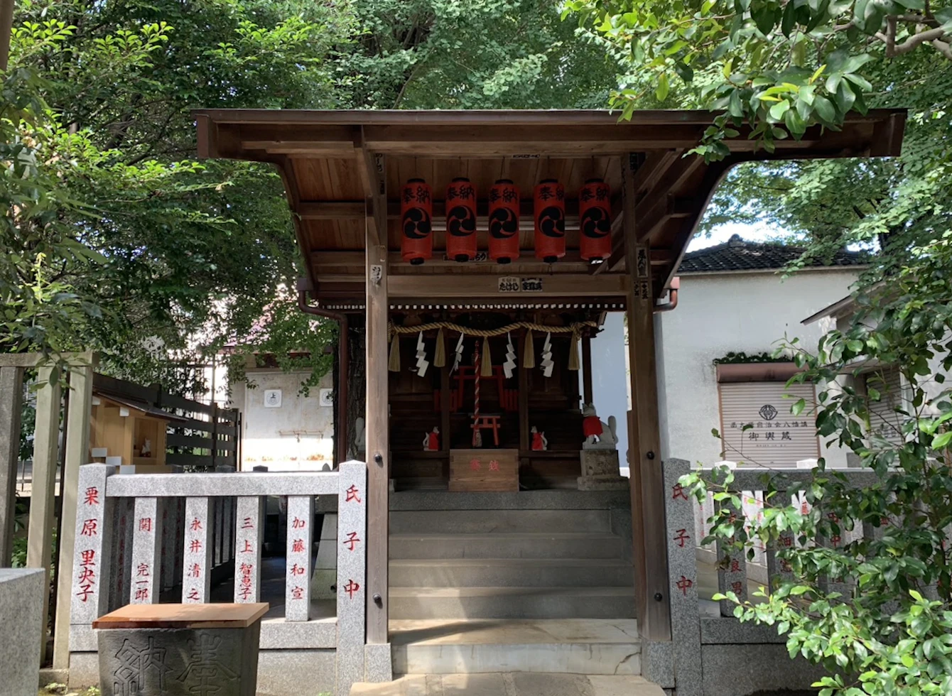 富士・榛名・稲荷の三柱をお祀りする末社の社殿。軒に朱の奉納提灯が並ぶ。