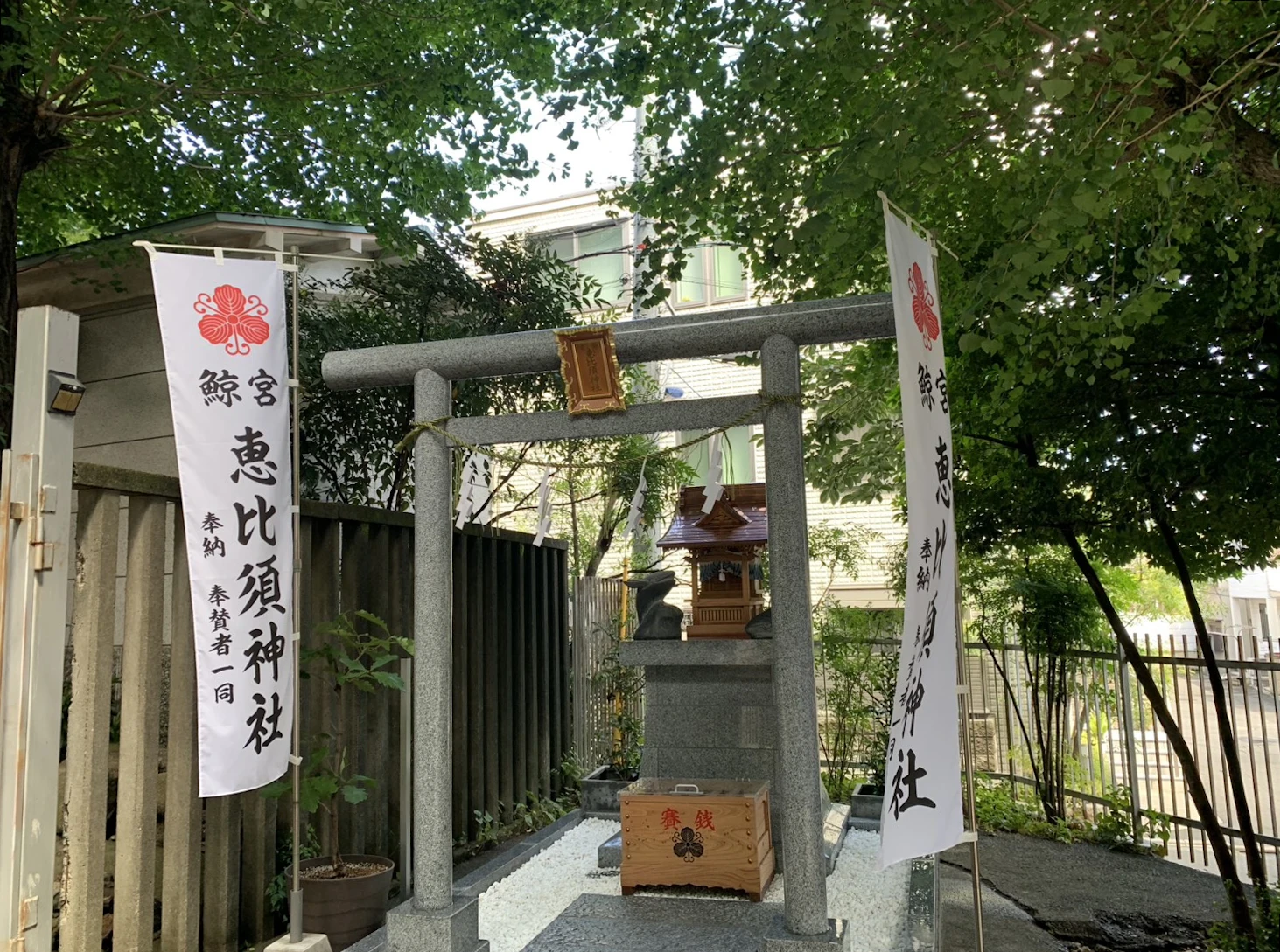 鯨宮 恵比須神社の石鳥居と社殿。左右に社名を記した幟が立つ。